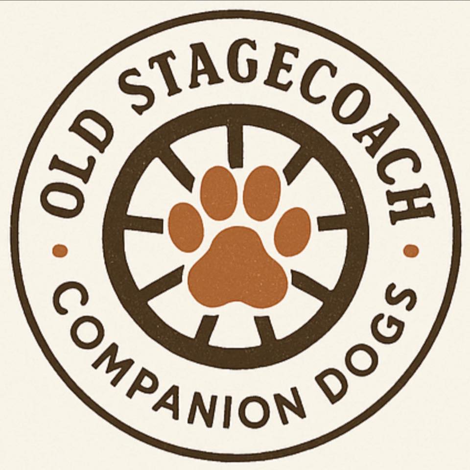 Circular logo for Old Stagecoach Companion Dogs. The outer ring features the program name in brown text with small orange dots on each side. Inside the circle is a brown stagecoach wheel with an orange paw print in the center.